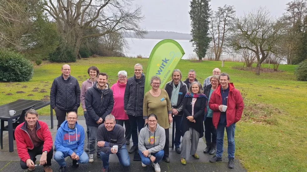 Gruppenfoto der Teilnehmenden des bewirk Netzwerktreffens. IM Hintergrund sind eine Wiese, Bäume und ein See.