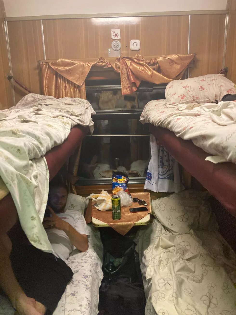 Abteil im Nachtzug der Freudnschaft nach Moldova. Vier Etagenbetten mit Bettwäsche und einem Tisch in der Mitte, auf dem Getränke und Essen stehen.